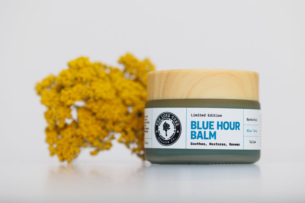 Blue Hour Tallow Balm jar with wood grain lid by Lone Tree Tallow Co. Bakuchiol and blue tansy face balm for fine lines and glow. Jar sitting next to dried bouquet of wild yarrow. 