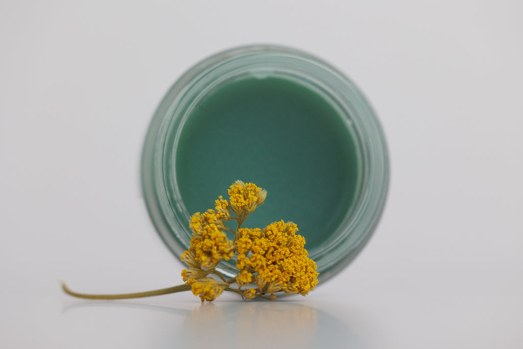 Blue Hour Balm open jar showing blue -green tinted balm colored by blue tansy. Formula includes bakuchiol, local beeswax, wild yarrow and calendula infused sunflower and safflower oils. Chemist-formulated tallow skincare from the prairie.
