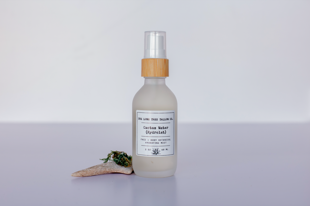 a picture of lone tree tallow co. cactus water hydrolat in a 2 oz frosted white glass spray bottle with a bamboo top. 